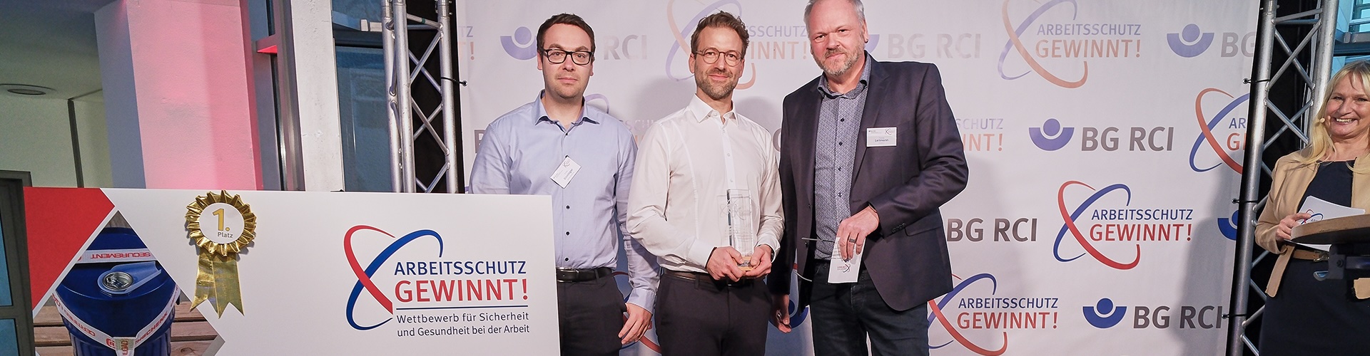 (v. l.): Jonas Binninger und Andreas Unterhuber (Wacker Chemie AG) mit Thomas Leitmann, Vorsitzender des Präventionsausschusses der Vertreterversammlung der BG RCI 